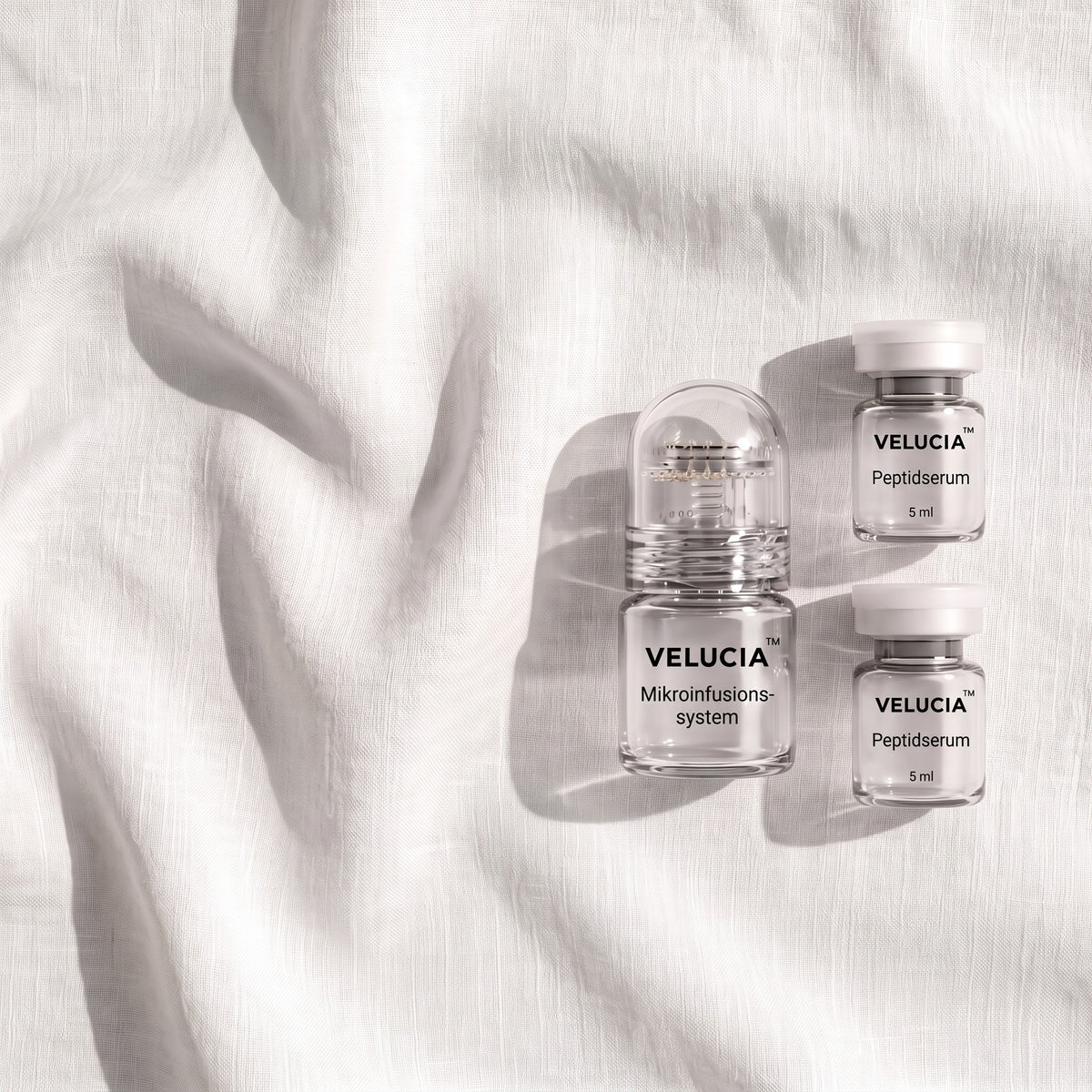 Das Velucia System und zwei Serum-Ampullen auf weißem Leinen