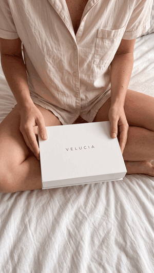 Das Velucia Kit wird ausgepackt: Box öffnen, Etuis herausnehmen, Inhalt auf dem Bett ausbreiten